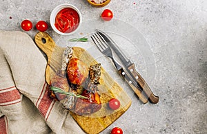 Grilled chicken drumstick bbq on a cutting board on a stone gray background
