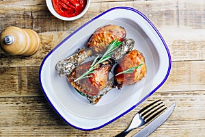 Grilled chicken drumstick bbq with rosemary on a rustic wooden background