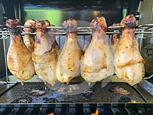 Grilled chicken drumsticks are cooked in gas grill