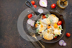 Grilled chicken fillet and various vegetables on a cast-iron frying pan. Copy space, top view flat lay background