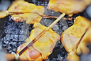 Grilled chicken four legs thigh on the flaming grill
