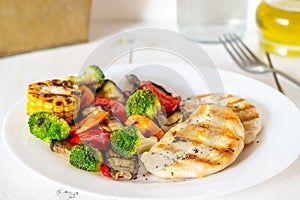 Grilled chicken with grilled vegetables on a wooden background. Healthy eating