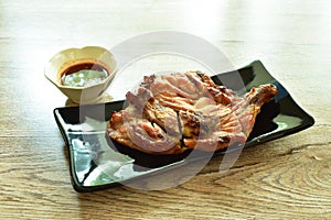Grilled chicken hip and leg on plate dipping with spicy tamarind sauce