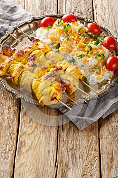 Grilled chicken kebab is known as jujeh kabab with rice closeup on the plate. Vertical