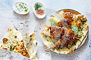 Grilled chicken kebabs chicken skewers with herbed garlic butter naan tortillas and Greek tzatziki sauce.