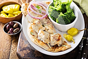 Grilled chicken kebabs on a pita