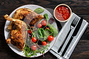 Grilled chicken leg quorters with salad mix and tomatoes.