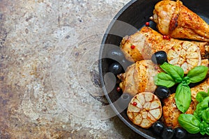 Grilled chicken legs with garlic, basil, olives and spices