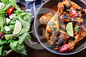 Grilled chicken legs, lettuce and cherry tomatoes limet olives. Traditional cuisine. Mediterranean cuisine