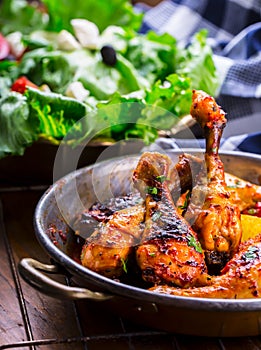 Grilled chicken legs, lettuce and cherry tomatoes limet olives. Traditional cuisine. Mediterranean cuisine