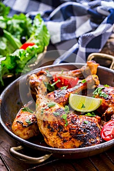 Grilled chicken legs, lettuce and cherry tomatoes limet olives. Traditional cuisine. Mediterranean cuisine