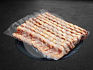 Grilled chicken lulas. Vacuum-packed minced meat products. Isolated on a dark background photo