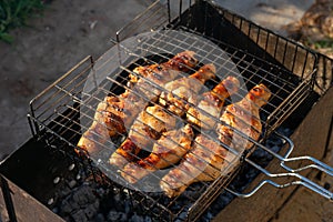 Grilled chicken meat, chicken legs on grill grid. Cooking outside as picnic time with barbecue