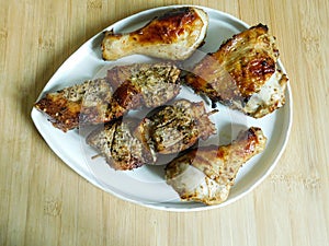 grilled chicken and pork barbecue meat on a wooden board.