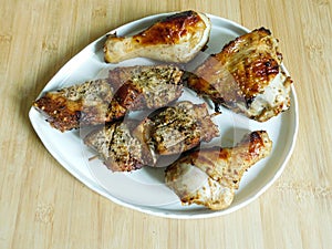 grilled chicken and pork barbecue meat on a wooden board.