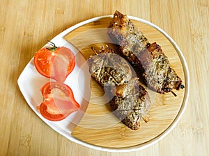 grilled chicken and pork barbecue meat on a wooden board.