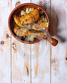 Grilled chicken with potatoes in a rustic bowl. Typical spanish tapa. photo