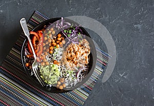 Grilled chicken, rice, spicy chickpeas, avocado mash, cabbage, pepper buddha bowl on dark background, top view. Delicious balanced