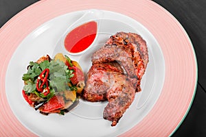 Grilled chicken and salad with grilled vegetables in plate on dark wooden background. Hot Meat Dishes.