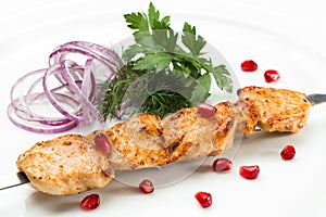 Grilled chicken on a skewer close up on a white background. Chicken mini-kebab close up