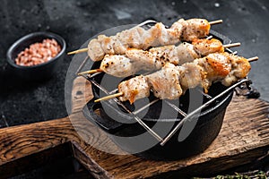 Grilled Chicken skewers souvlaki, poultry meat shish kebab. Black background. Top view