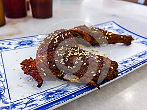 Grilled chicken with spicy sauce served in Chinese style with sesame seed