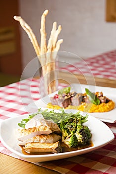 Grilled Chicken Steak in mushroom's sauce with grilled mushrooms and broccoli served in a white plate