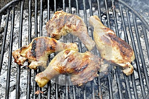 Grilled chicken thigh on the flaming grill.