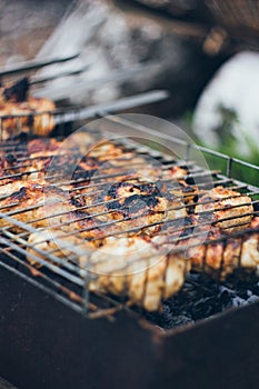 Grilled chicken thighs on the flaming grill