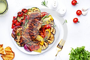 Grilled chicken and various vegetables. Paprika, zucchini, eggplant, mushrooms, tomatoes, onion salad with rosemary on plate,