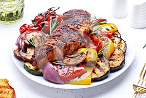 Grilled chicken and various vegetables. Paprika, zucchini, eggplant, mushrooms, tomatoes, onion salad with rosemary on plate,