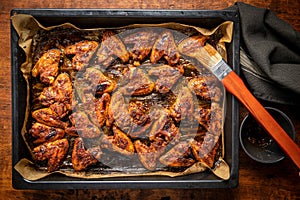 Grilled chicken wings in barbecue sauce in baking tray