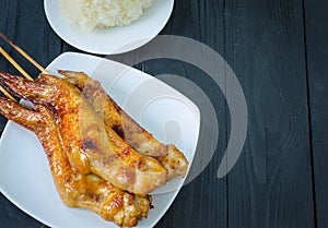 Grilled chicken wings and sticky rice in dish