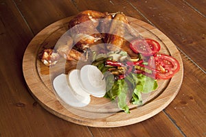 Grilled chicken wings on a wooden plate