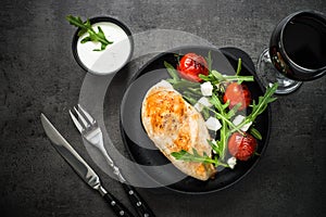 Grilled chiken fillet and fresh salad with white sauce.