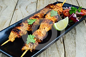 Grilled cnicken kebab served with salad and lime