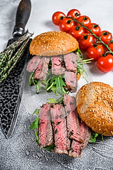 Grilled cold cuts roast beef burger sandwich with arugula and spinach. White background. Top view