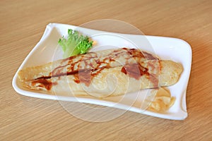 Grilled Dolly fish steak served on white plate on wood table background.