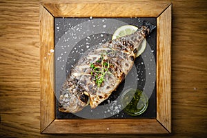 Grilled dorada fish with lemon and spinach photo