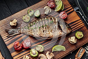 Grilled Dorada fish, sea bream with the addition of spices, herbs and lemon on the grill plate