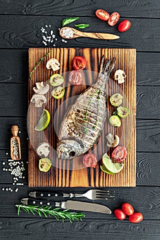 Grilled Dorada fish, sea bream with the addition of spices, herbs and lemon on the grill plate