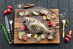 Grilled Dorada fish, sea bream with the addition of spices, herbs and lemon on the grill plate