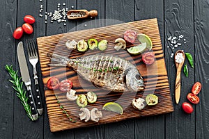Grilled Dorada fish, sea bream with the addition of spices, herbs and lemon on the grill plate