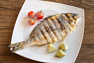 Grilled dorada with lemon and cherry tomatoes