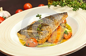 Grilled dorado fish with fried potatoes, lemon and tomato