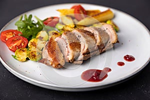 Grilled duck breast fillet with Brussels sprouts, mini corn, cherry tomatoes, arugula and lingonberry sauce.