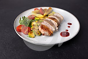 Grilled duck breast fillet with Brussels sprouts, mini corn, cherry tomatoes, arugula and lingonberry sauce.