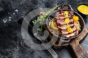 Grilled duck meat breast fillet steak with noodles and tangerines sauce. Black background. Top view. Copy space