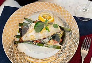 Grilled fillet of dorada with lemon, vegetables and white sauce