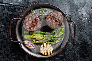 Grilled Fillet Mignon Steak with roasted asparagus. Black background. Top view